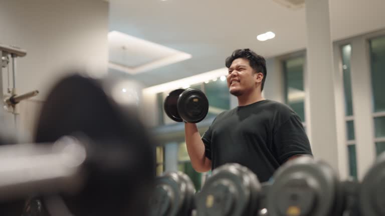 Overweight man using dumbbells for workout