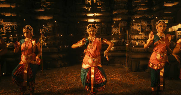 portrait of three expressive young indian dancers performing folk dance choreography inside an ancient temple. women in traditional clothes dancing bharatanatyam in colourful sari - shiva posture imagens e fotografias de stock