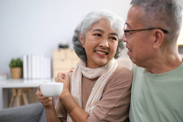 istock Affectionate senior Asian couple sharing warm embrace on the sofa, celebrating their enduring love and togetherness. Elderly husband and wife happy family 1767134581