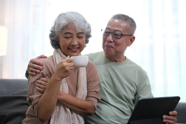 istock Affectionate senior Asian couple sharing warm embrace on the sofa, celebrating their enduring love and togetherness. Elderly husband and wife happy family 1767135106