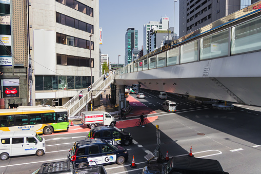 Tokyo, Japan - April 11, 2023: intersection with pedestrian overpasses in Shibuya, with unidentified people. Shibuya is a major commercial and finance center