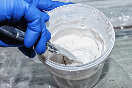 Manual mixing of white plaster with a spatula