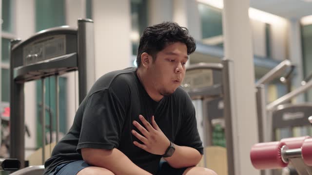 Overweight man feeling chest pain while exercising