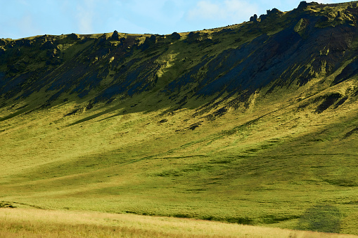 Rolling green hills under a clear blue sky.