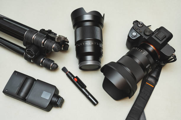 istock Modern photographic equipment, a mirrorless camera with a lens, an interchangeable lens, a flash, a tripod and a brush for cleaning lenses and other photographic equipment. 1767169142