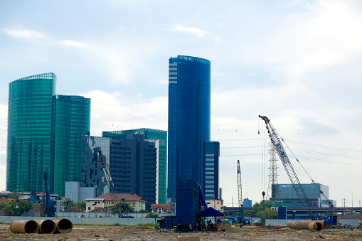 Modern office building skyline behind construction site area in Bangkok Chatuchak. Left building is Ministry of Energy Joint Service Center