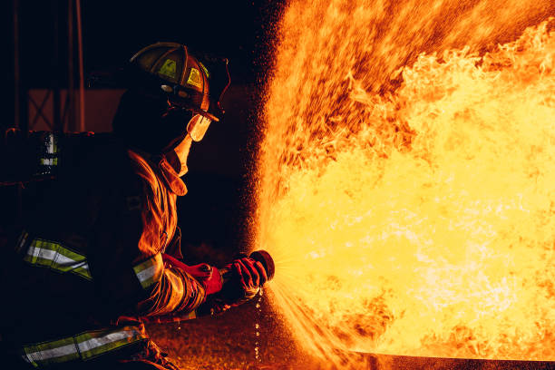 istock Firefighter Concept. Fireman using water and extinguisher to fighting with fire flame. firefighters fighting a fire with a hose and water during a firefighting training exercise 1767183259