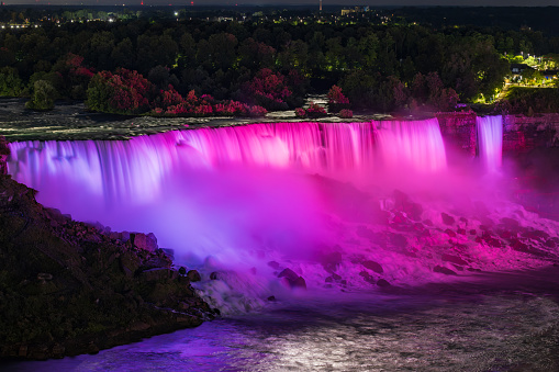 Pink illuminated American falls at night, Niagara Falls, USA