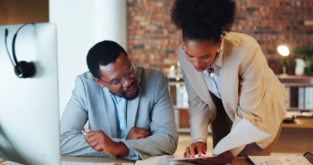 istock Business people, manager and teamwork with documents, finance report and budget proposal or sales report at night. Professional woman and man talking, collaboration or reading paperwork for feedback 1767192931