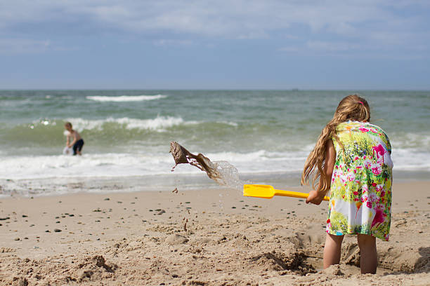 Happy 5 year old little girl having fun building sand castles on the beach