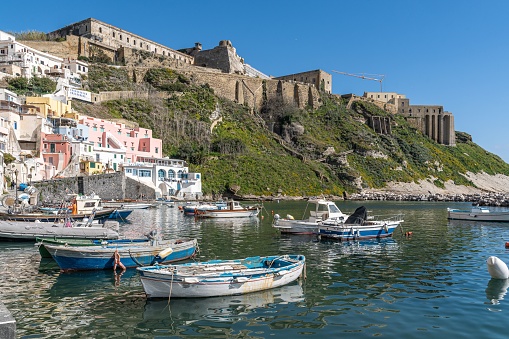 A scenic view of a tranquil bay featuring numerous boats and buildings in Procida, Campania, Italy