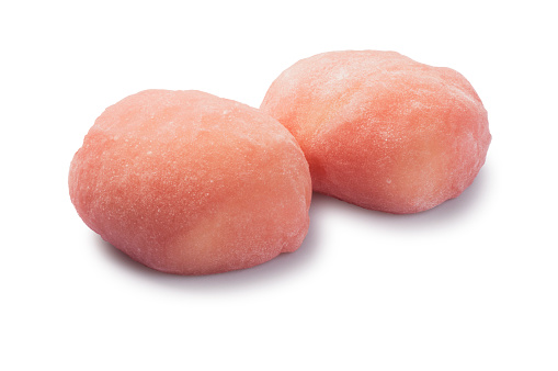 Studio shot of a two small strawberry cheesecakes mochi cut out against a white background