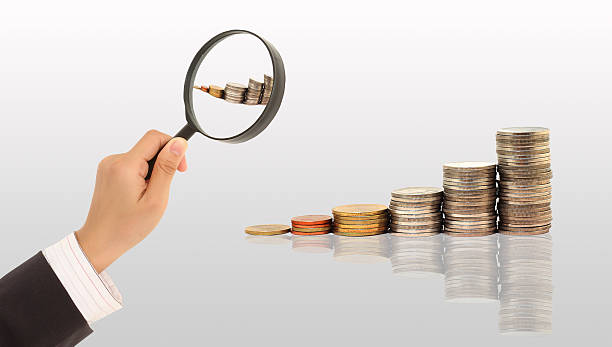 istock Magnifying glass and lots of gold coins 176721721