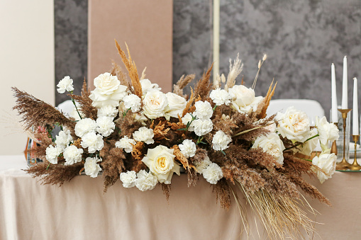 Wedding decorations. Wedding event. Decor of the wedding table with fresh flowers and pampas grass.