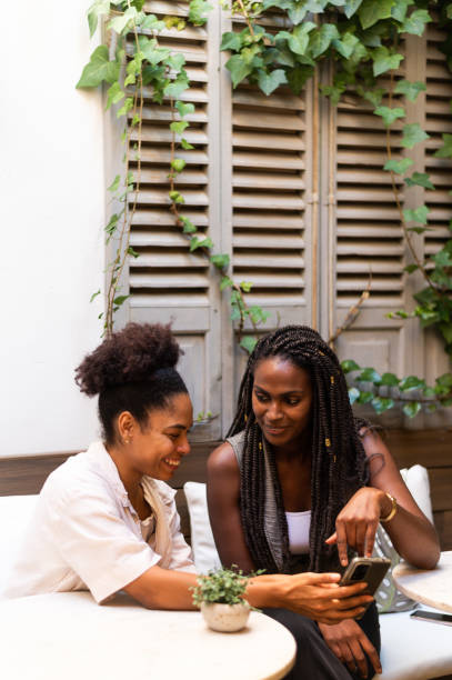 istock African young woman using phone in an outdoor cafeteria 1767231008