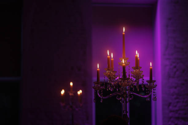 Candelabra with candles in a purple backlit background. Creepy or romantic atmosphere concept.