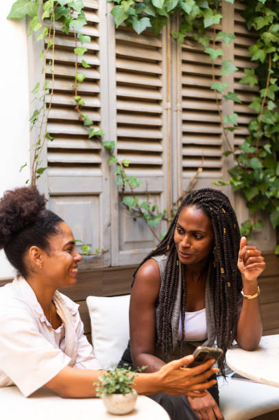 istock Afro young woman using phone sitting on a comfortable cafeteria 1767231517