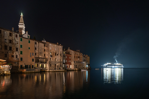 Rovinj, Croatia - October 11, 2023: Illuminated cruise ship in the sea near the old town