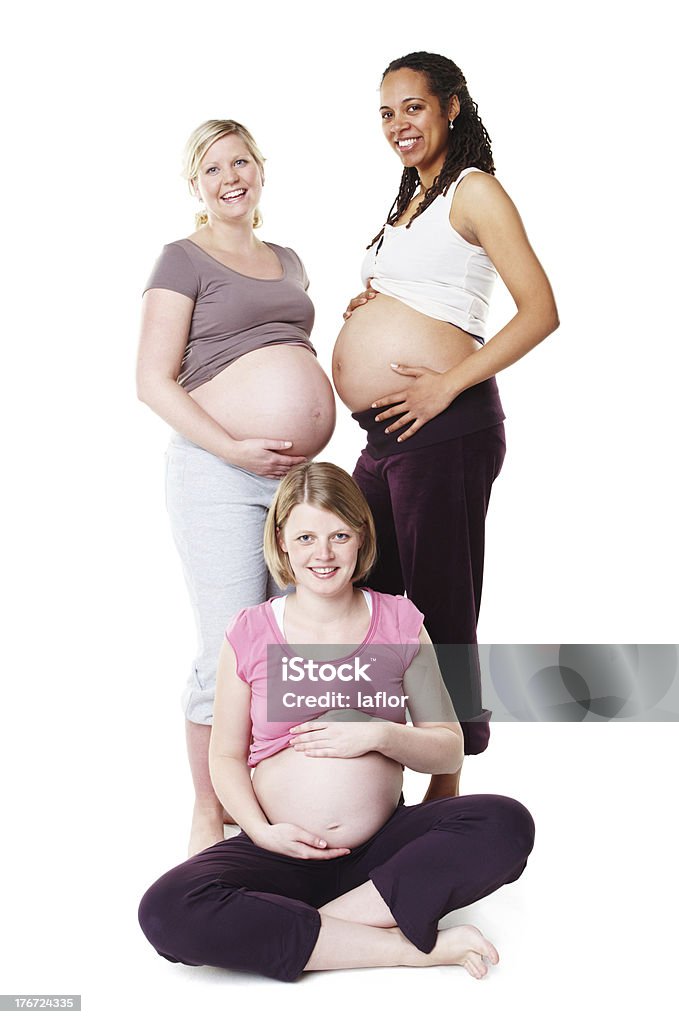 Looking beautifully pregnant Pregnant friends displaying their bellies together while isolated on white Pregnant Stock Photo