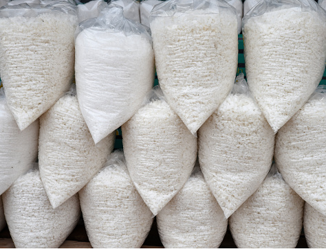 Large pellets of white raw salt packed in clear plastic bags stacked on top of each other.