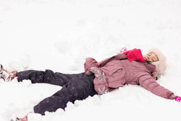 istock Girl laying on snow and making angel 1767246922