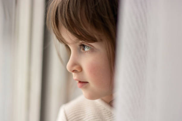 istock Girl standing next to window 1767248120