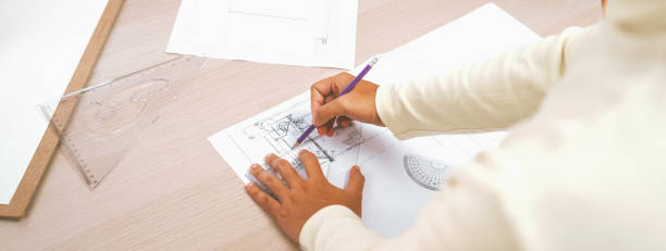 istock Cropped image of skilled engineer hand draws blueprint. Back view. Variegated. 1767248689
