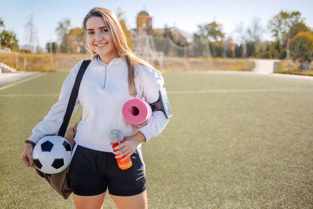 ritratto di giovane donna preparata per l'allenamento di calcio che tiene il tappetino per esercizi - pantaloncini da corsa foto e immagini stock