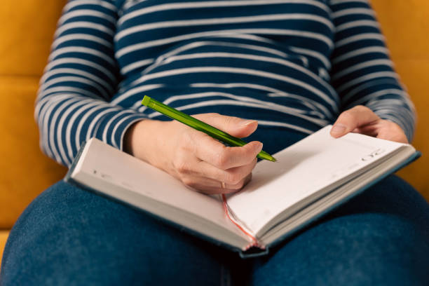 istock woman in jeans and a striped sweater makes notes in a notepad 1767276422