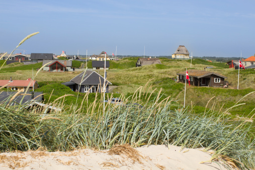 Panoramic view of summer houses at the North Sea shores of Western Jutland, Denmark. Sun is shining and the sky is bright blue.