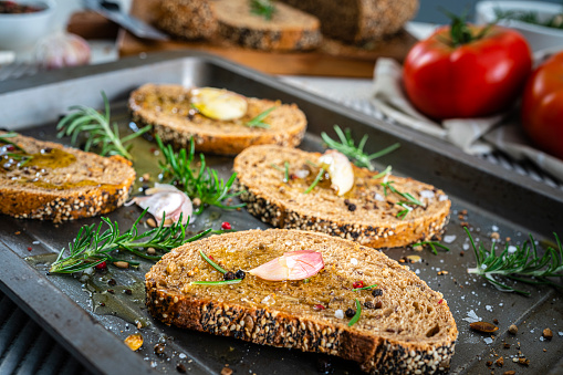 Baking sheet with slices of bread ready to toast in the oven