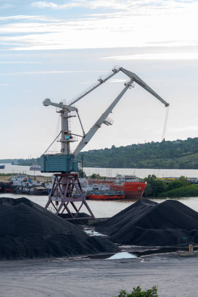 istock Port crane stands by heaps of coal 1767292514