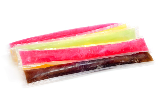 some freezies of different colors and flavors on a white background