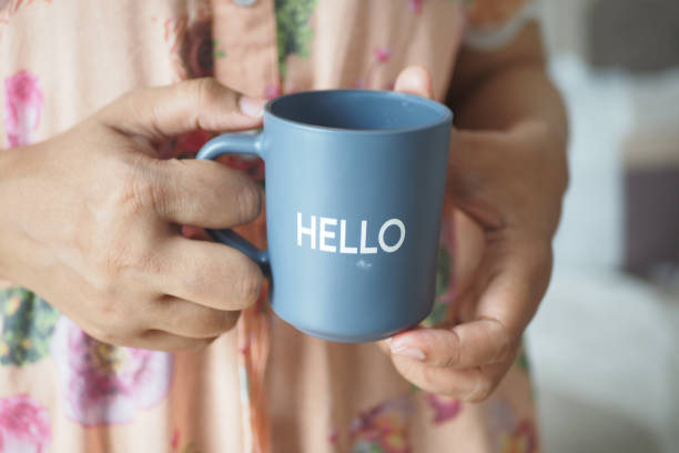 istock women holding a blue coffee cup with hello word 1767306088