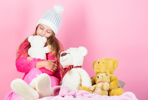 Why kids love stuffed animals. Kid little girl play with soft toy teddy bear on pink background. Toy every child dreaming. Happy childhood concept. Child small girl playful hold teddy bear plush toy.