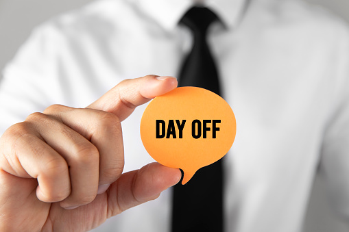Businessman with speech bubble shaped card with day off message