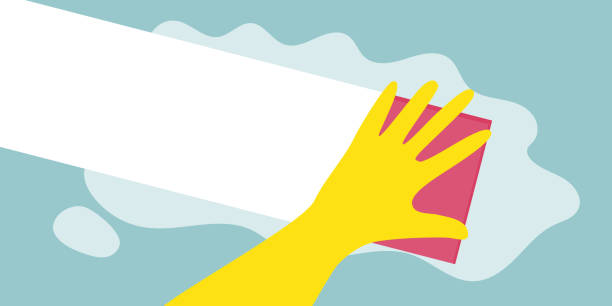 istock Hand in a yellow rubber glove with a pink cleaning sponge on a green background 1767322918