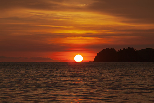 Costa Rican Sunset at playa Hermosa, Guanacaste, sun down next to an island