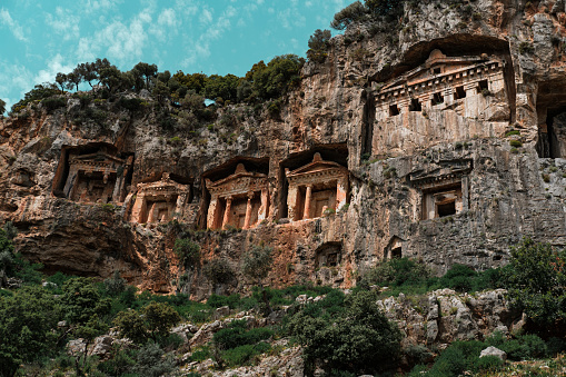 Dalyan Turquía antiguas tumbas del templo de Licia hundidas, árboles verdes, naturaleza asombrosa de Koycegiz, cielo azul con pequeñas nubes blancas, popular destino turístico de vacaciones photo