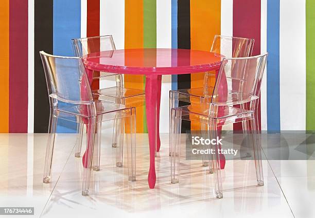 Lucite Chairs And A Pink Table Against Colorful Stripes Stock Photo - Download Image Now