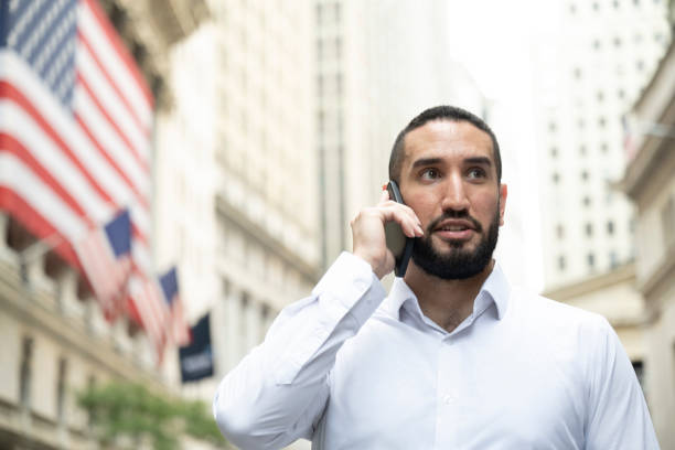 istock Bearded trader taking a break and using phone outdoors 1767347221