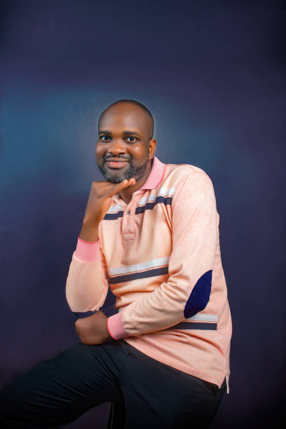 istock A man  Seated with hands on face area  and hands touching, looking at camera with  a smile 1767350369