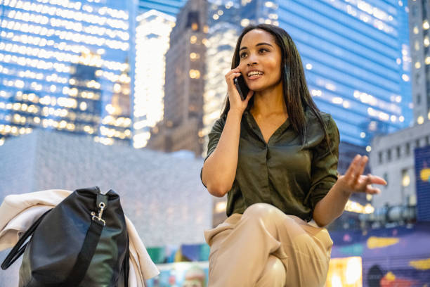 Manhattan businesswoman sitting outdoors and using phone
