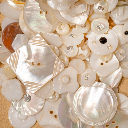 Close up of a group of pearl buttons some with rhinestone decoration.
