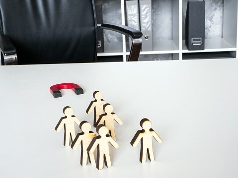 Talent employee Retention and Retaining. Office desk with magnet and figures.