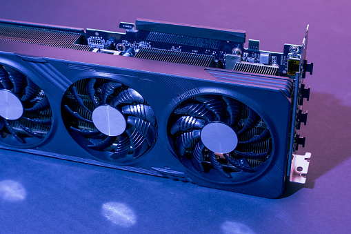 a modern powerful gaming graphics card for a computer with three fans. the concept of PC hardware. Gaming video card with neon backlight