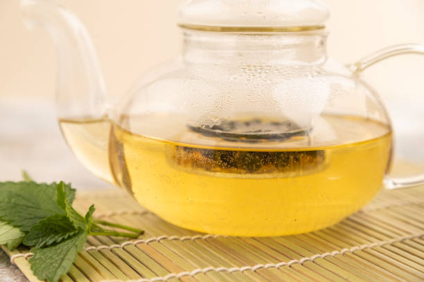 istock Green oolong tea with herbs in glass on brown concrete. Side view, selective focus. 1767398860