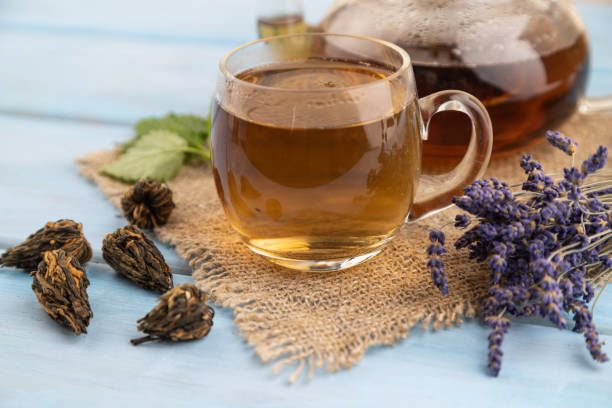 istock Red tea with herbs in glass on blue wooden. Side view, selective focus. 1767409821