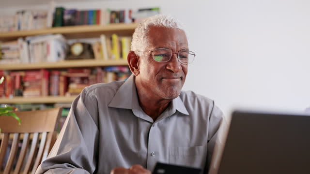 Senior black man with credit card making a purchase on laptop computer