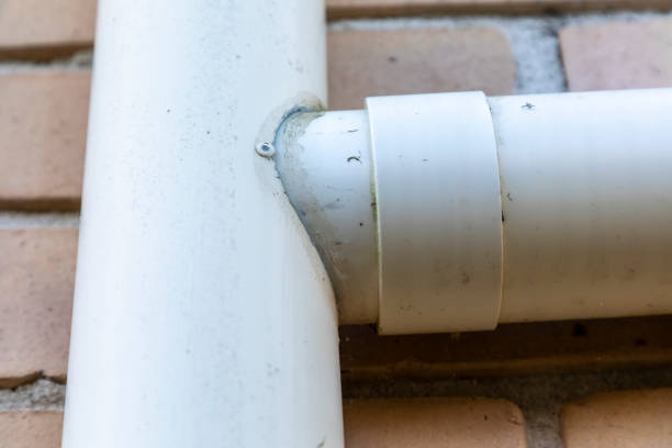 istock Plastic rain down pipe and feeder pipe conneceted to brown bricks on a house 1767420986